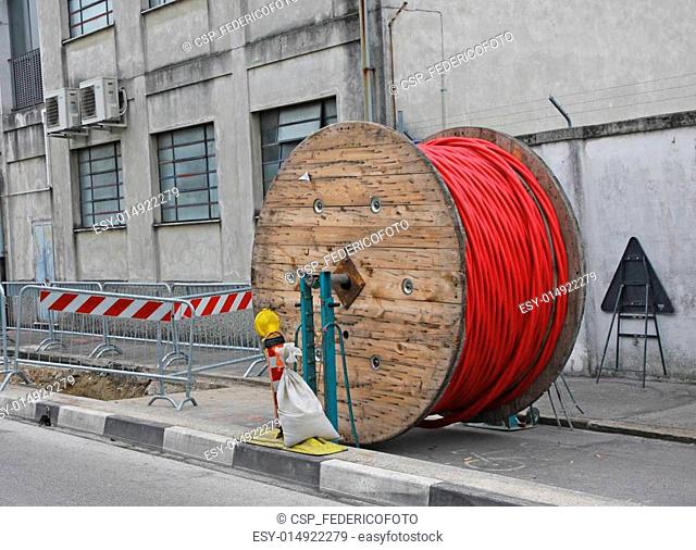 excavation at a construction site during the installation of high-voltage electric cables and large wooden spool