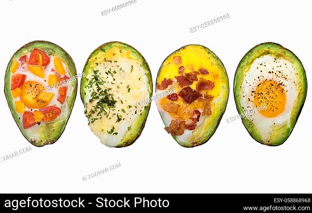 Variety of baked avocado with eggs isolated on white background