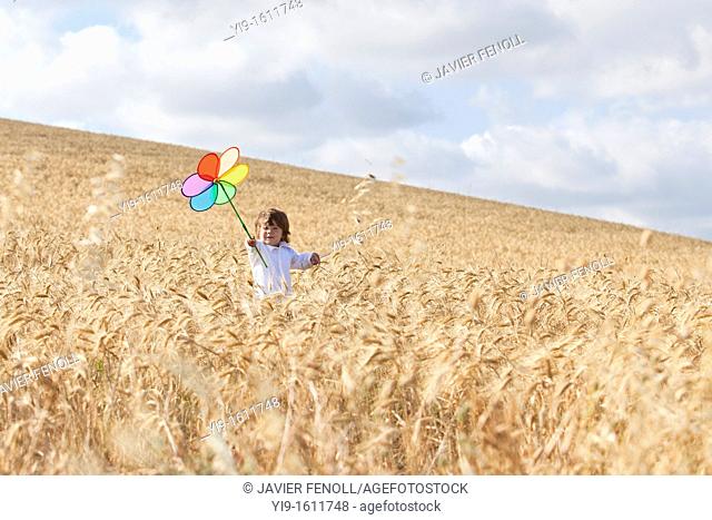 child with a pinwheel in the field