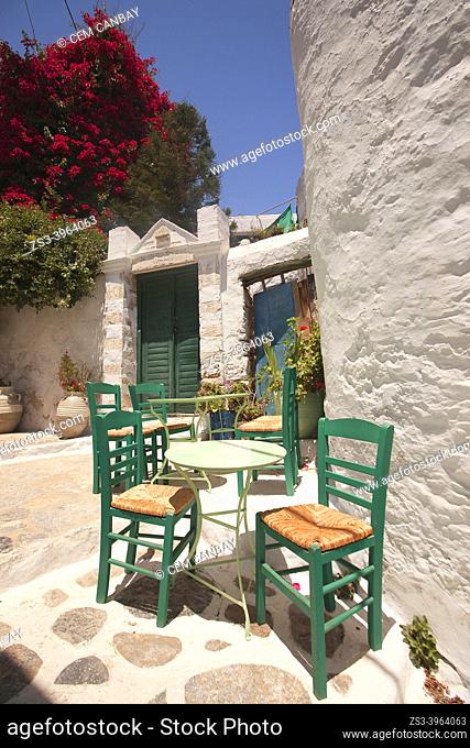 Tables and chairs of an open air cafe in the alleys of the old town Chora, Amorgos Island, Cyclades Islands, Greek Islands, Greece, Europe
