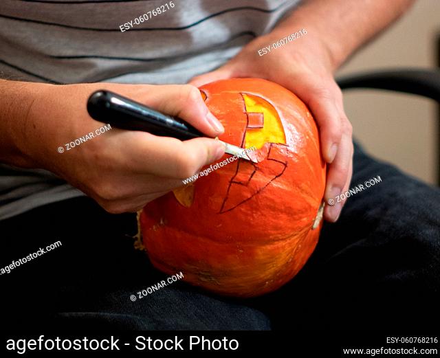 carving a Halloween pumpkin with a knife