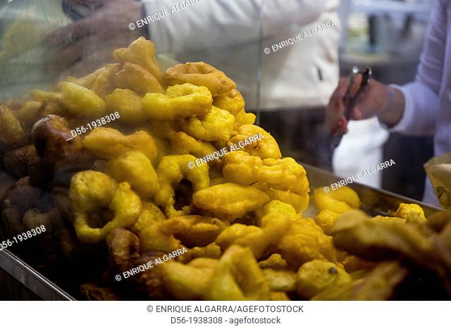 Man cooking buñuelos, a typical Spanish Fritters, in Fallas festival