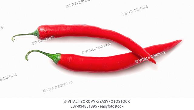 Two red chili peppers crossed isolated on white background