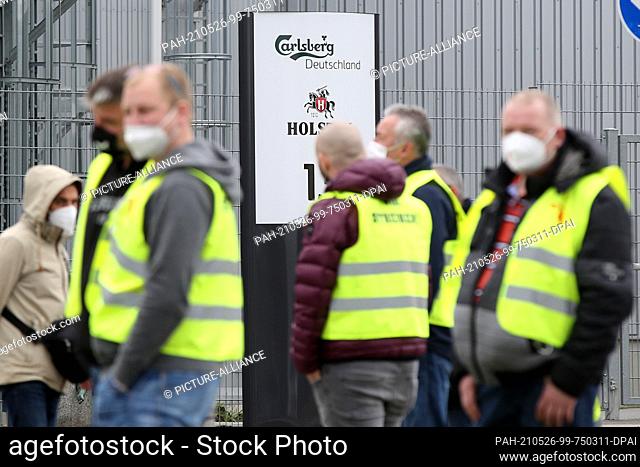 26 May 2021, Hamburg: Strikers stand in front of a Carlsberg Deutschland brewery in Hamburg-Hausbruch. In the wage dispute at North German breweries