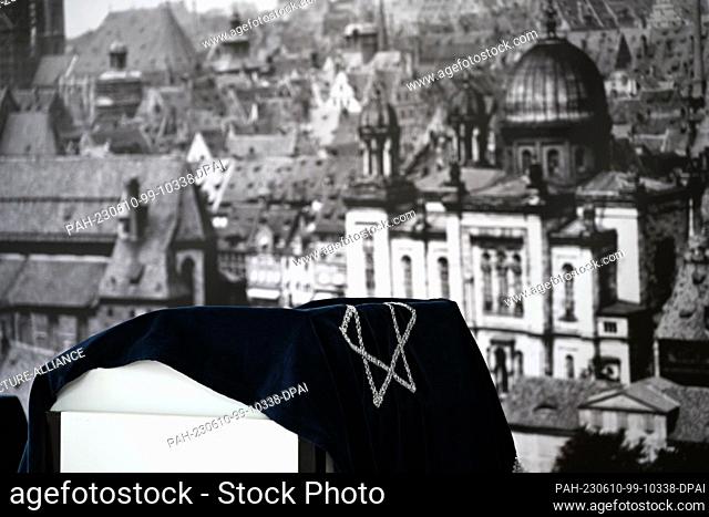 10 June 2023, Bavaria, Nuremberg: A dark blue cloth embroidered with a silver Star of David hangs above a lectern during the 38th German Protestant Church...