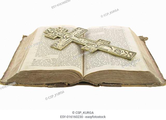 Very old vintage open bible and big church cross on it isolated over white background