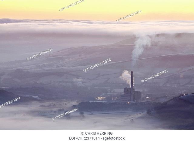 England, Derbyshire, Hope Valley. Hope Valley Cement Works shrouded in mist at sunrise in the Peak District National Park
