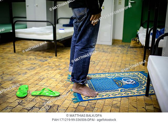 29-year-old homless man Bara from Burkina Faso prays at the night shelter for homeless people on the grounds of the Bayernkaserne ('Bavaria barracks') in Munich