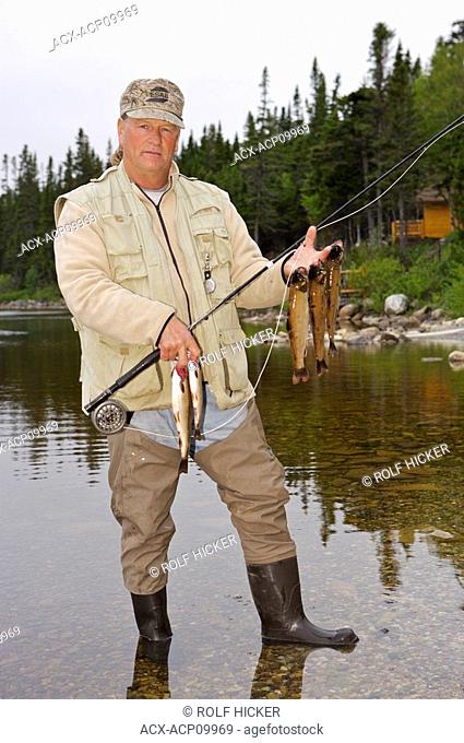 Fisherman with a catch of Speckled Trout, caught near Tuckamore Lodge, Main Brook, Viking Trail, Great Northern Peninsula, Newfoundland & Labrador, Canada