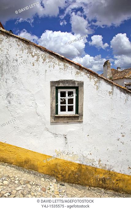 Rustic Green Window against a Whitewashed Wall with a Yellow Border