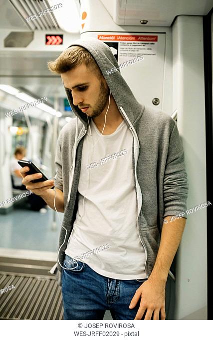 Young man using smartphone in metro