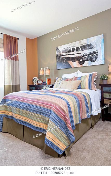 Interior of bedroom with multi colored bedsheet on bed
