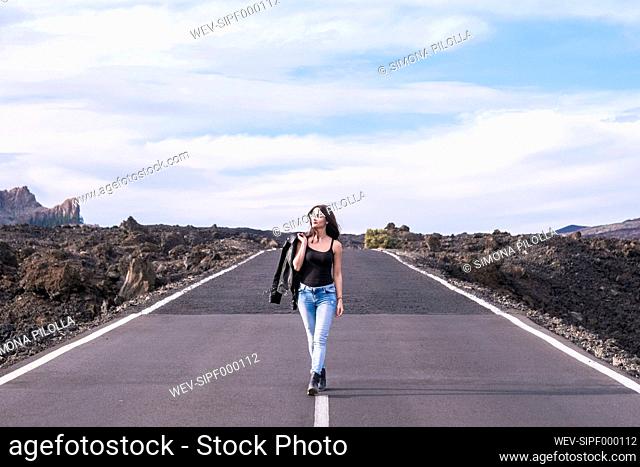 Spain, Tenerife, woman walking on an empty road