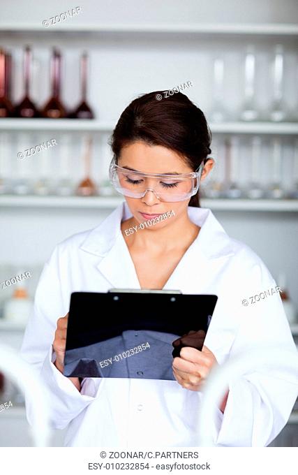 Portrait of a scientist writing on a clipboard