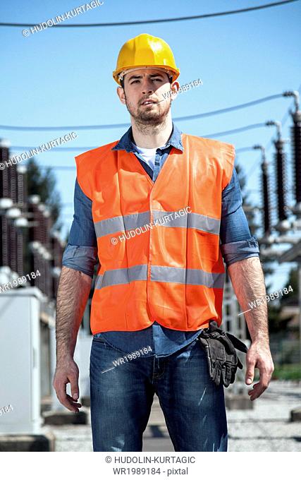 Portrait of engineer against electricity substation