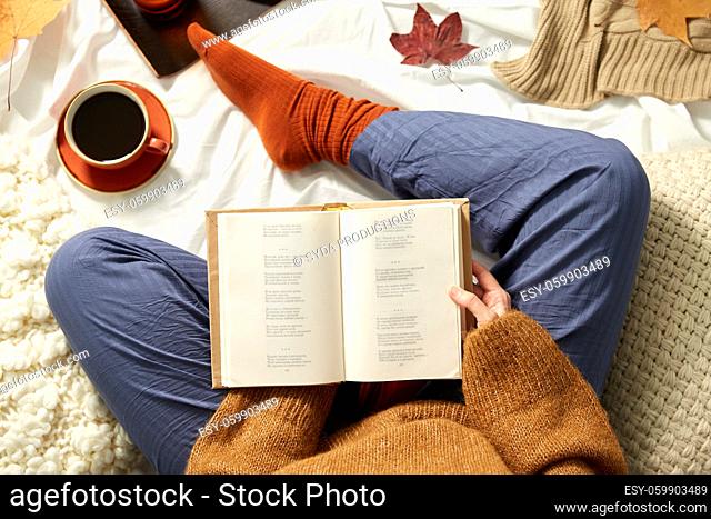 young woman reading book at home in autumn