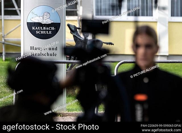 09 June 2022, Hessen, Bad Arolsen: A stele from the Kaulbach secondary school in Bad Arolsen in northern Hesse is seen behind a television crew