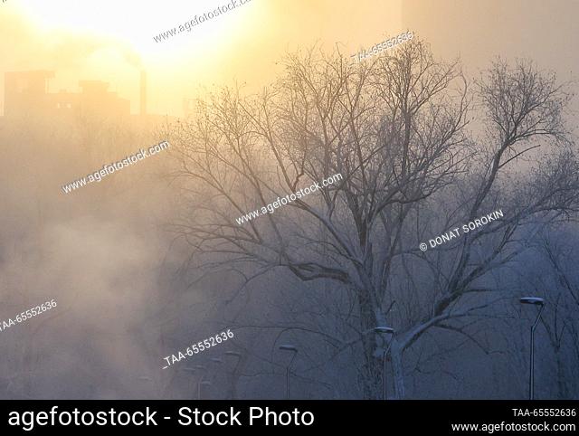 RUSSIA, YEKATERINBURG - DECEMBER 8, 2023: Sunset over a park by the Iset River as severe frost hits the city. On 8 December
