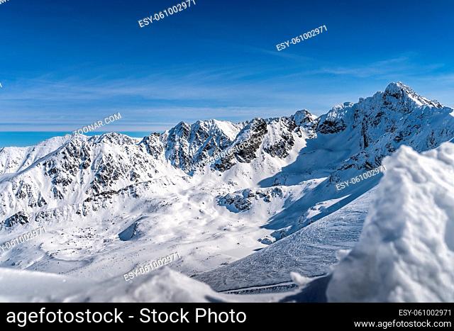 View from Kasprowy Wierch at Swinica mountain peak at winter. Amazing mountain range with snow capped mountain peaks in Tatra Mountains, Poland