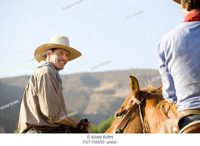 Two cowboys riding horses