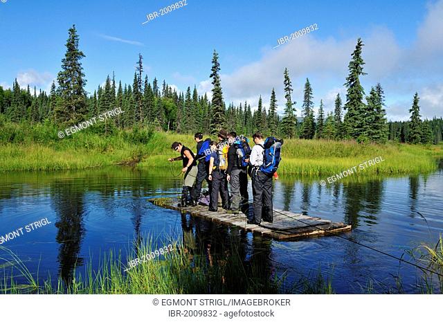 Group of tourists crossing a small river on a cable ferry, Kroto Lake, Alaska, USA, North America