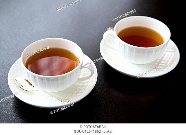 Two cups of tea, high angle view, black background