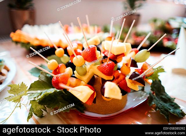 fruits on a stick served in a plate