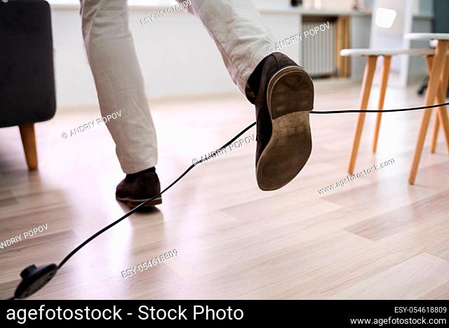 Close-up Of A Man Legs Stumbling With An Electrical Cord At Home