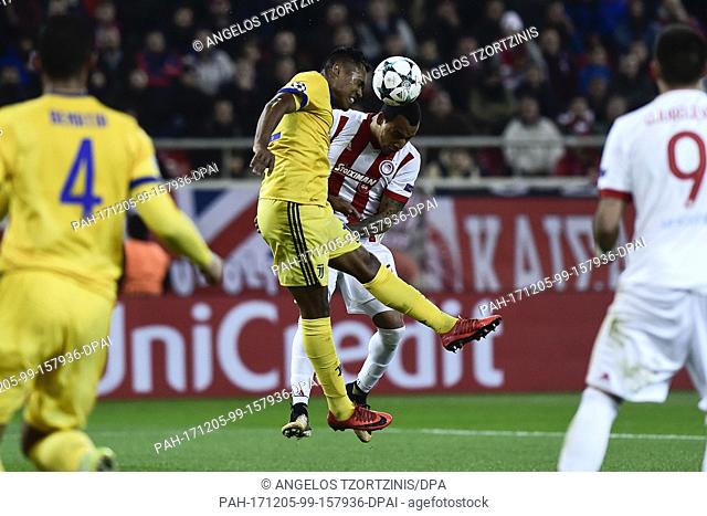 Juventus' Alex Sandro and Olympiacos' Felipe Pardo (R) vie for the ball during the Champions League group match between Olympiacos Piraeus and Juventus Turin at...