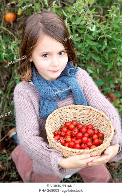 Girl holding tomatoes from garden in the palms of her hands