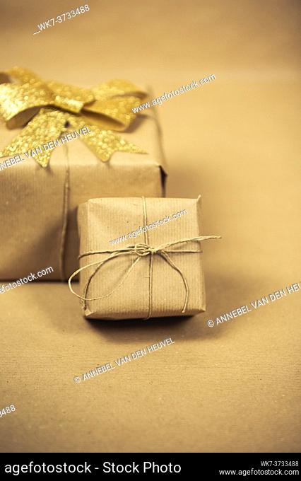 Brown paper gift boxes with gold ribbon wrapping decoration for birthday, Valentine's day, mother's day other party concept background texture