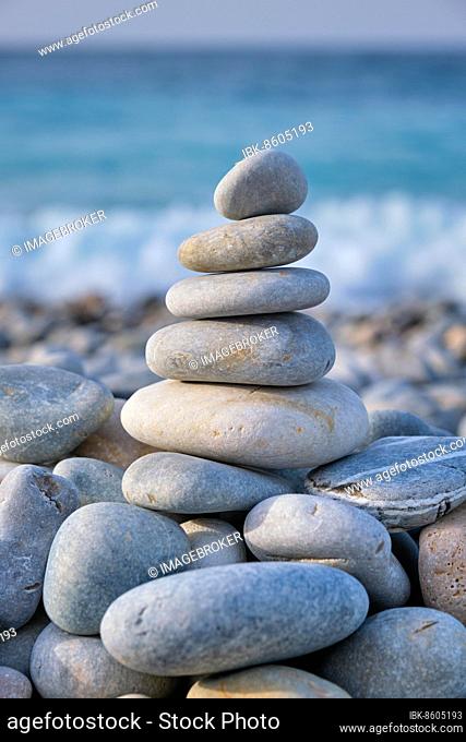 Zen meditation relaxation concept background, balanced stones stack close up on sea beach