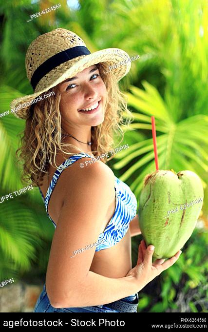 Portrait of an exotic girl drinking from a coconut