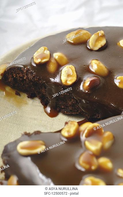 A brownie cake with salted caramel and roasted peanuts (close up)