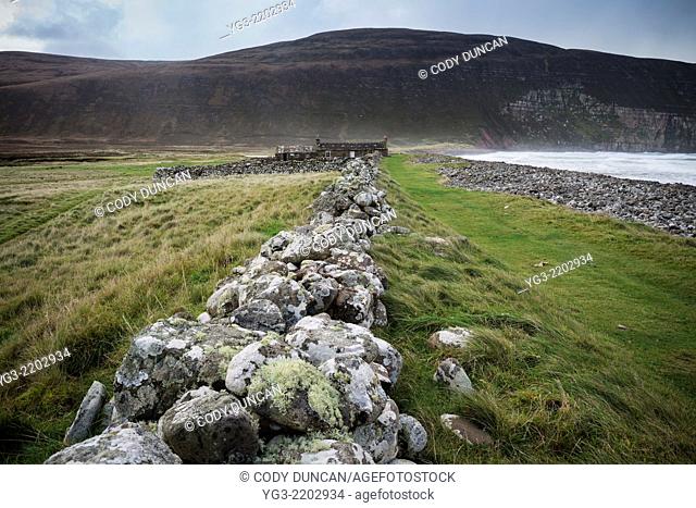Old stone wall leads towards Burnmouth Bothy, Rackwick Bay, Hoy, Orkney, Scotland
