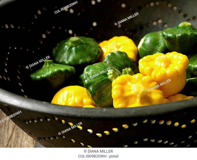 Fresh organic vegetables, patty pans yellow and green in metal colander