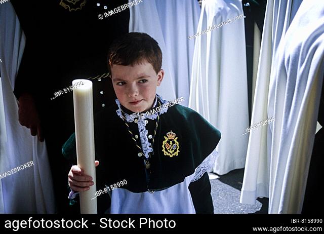 Achild in the respective brotherhood uniform during Semana Santa in Seville, Andalusia, Spain, Europe