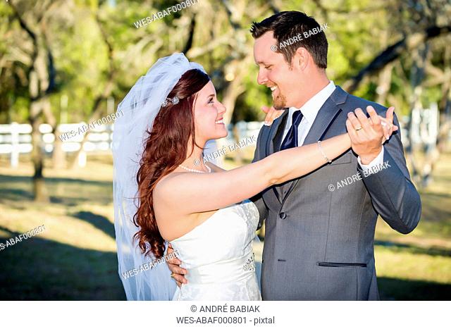 USA, Texas, Young wedding couple looking at each other, smiling