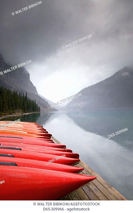 Red canoes and lake in early winter. Lake Louise, Banff National Park. Alberta, Canada