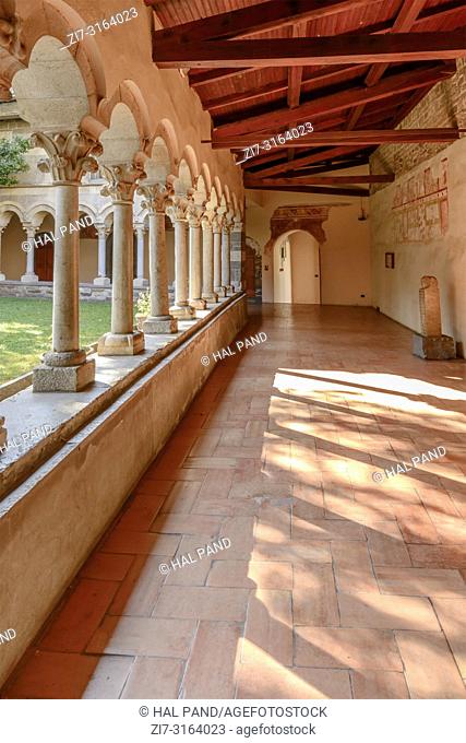 detail of light on floor through mullions and arches at Romanesque cloister of Abbey on shore of Lario lake, shot in bright fall light at Piona, Lecco, Italy