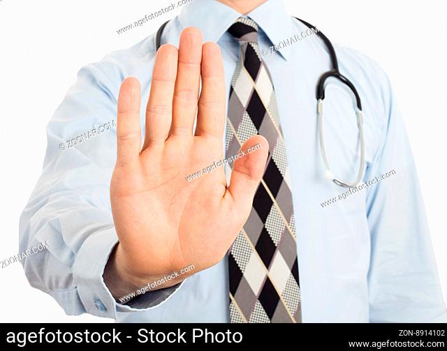 Male doctor holding up his hand in a Halt or Stop gesture as he signals he has had enough, or denies access or tells someone to go away, isolated on white