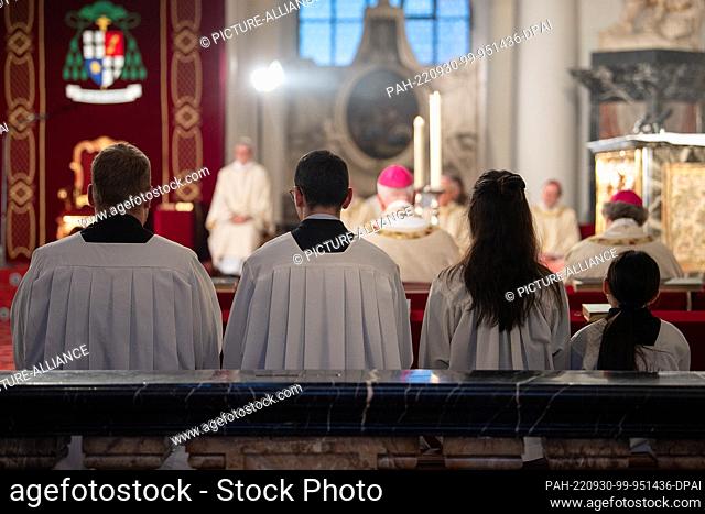 PRODUCTION - 28 September 2022, Hesse, Fulda: Altar boys sit next to each other during a morning service in Fulda Cathedral as part of the fall plenary session...