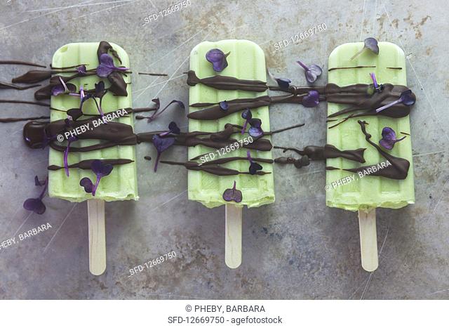 Avocado and lime ice cream on a stick with chocolate and radish cress