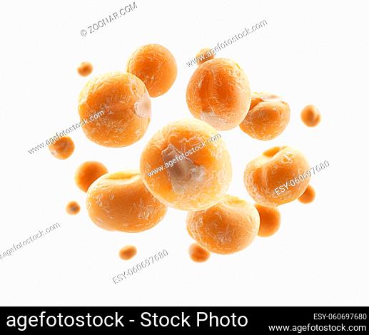 Dry yellow peas levitate on a white background