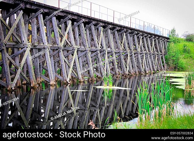 An old trestle railroad bridge spanning a pond