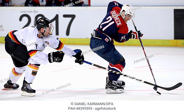 Germany's Daryl Boyle (L) in action against USA's Vince Trocheck during the ice hockey world cup friendly match between Germany and USA at the Arena in...