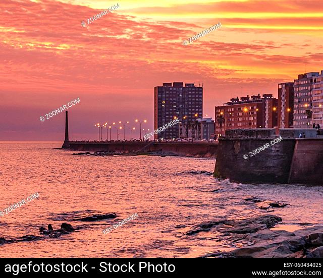 Beautiful urban coastal sunset scene at rambla sur, one of the boardwalks of montevideo city, uruguay