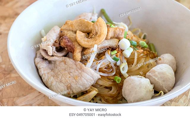 close up asian noodles with beef meatball and vegetable on wood background