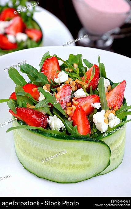portion of strawberry salad with arugula and ricotta in cucumber