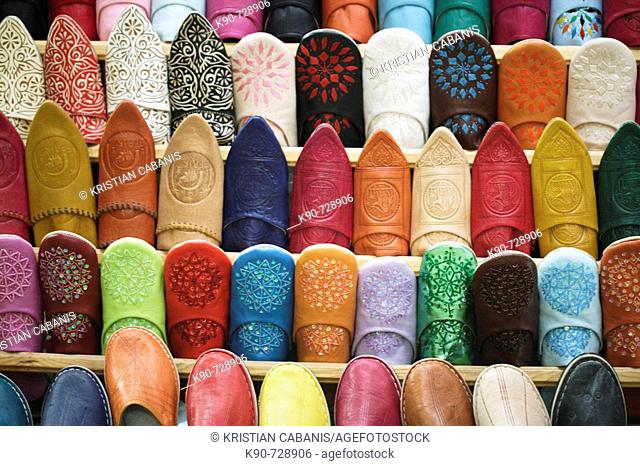 A stack filled with colorful baboushes - the traditional leather slippers of Morocco in the souq in the heart of the medina of Fès el-Bali, Fès, Morocoo